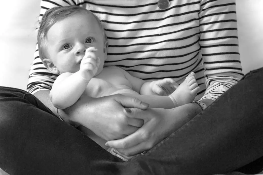 Bump to Beyond your Birth, mother sat crossed legged holding her baby