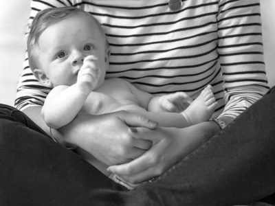 Mother sat crossed legged holding her baby - Bump to Beyond your Birth